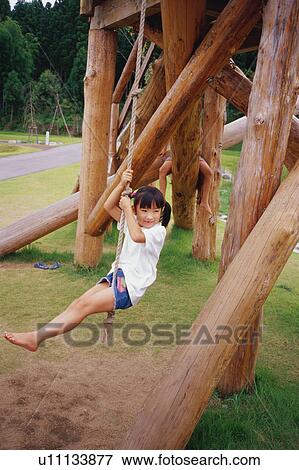 Stock Photo - Girl swinging on rope swing. Fotosearch