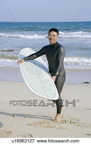 Man holding surfboard View Large Photo Image Stock Photo - Man holding surfboard. Fotosearch