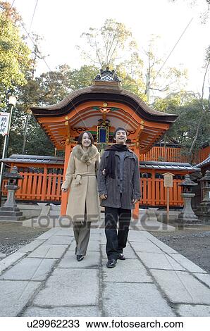 Stock Image - Couple walking at shrine. Fotosearch