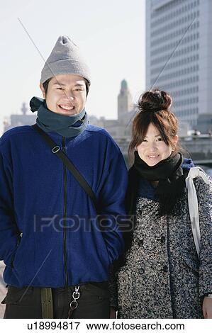Stock Photo - Portrait of young couple standing. Fotosearch