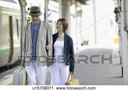 Senior couple walking on station platform View Large Photo Image Stock Image - Senior couple walking on station platform. Fotosearch
