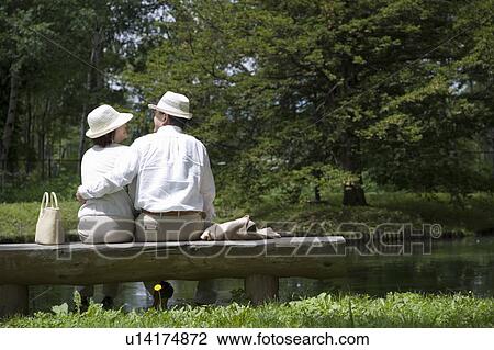 Mature couple sitting on bench View Large Photo Image Stock Image - Mature couple sitting on bench. Fotosearch