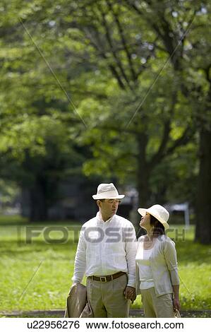 Stock Photograph - Mature couple walking in park. Fotosearch