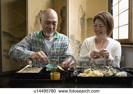 Stock Image - Senior couple eating soba. Fotosearch