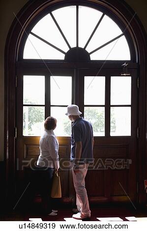 Stock Photo - Senior couple looking out window. Fotosearch