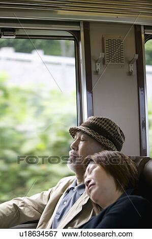 Stock Photo - Senior couple sleeping in train. Fotosearch