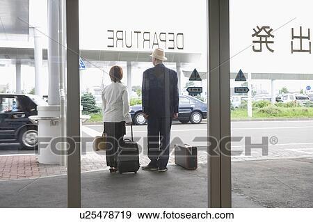 Stock Photo - Senior couple standing at airport. Fotosearch