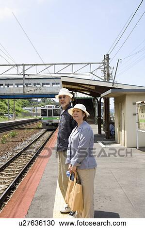 Senior couple standing at station View Large Photo Image Stock Image - Senior couple standing at station. Fotosearch