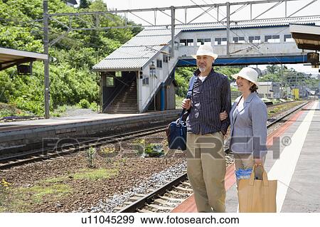 Stock Photo - Senior couple standing at station. Fotosearch