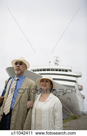Stock Image - Senior couple standing in front of ship. Fotosearch