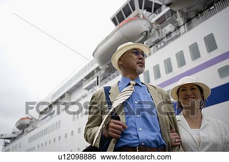 Stock Photograph - Senior couple standing in front of ship. Fotosearch