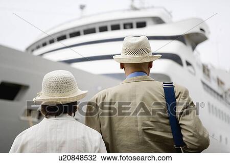 Senior couple standing in front of ship, rear view View Large Photo Image Stock Image - Senior couple standing in front of ship, rear view. Fotosearch