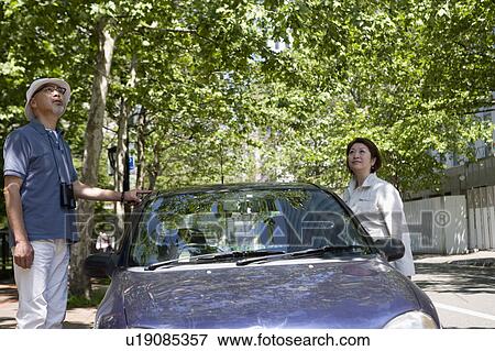 Stock Photo - Senior couple standing next to car. Fotosearch