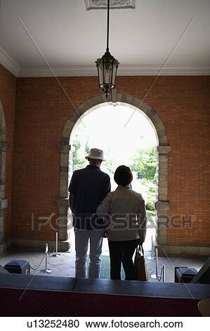 Stock Image - Senior couple standing, rear view. Fotosearch