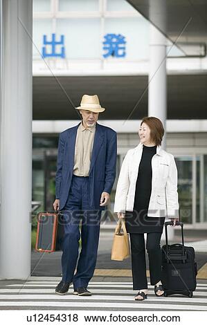 Stock Photo - Senior couple walking outside airport. Fotosearch