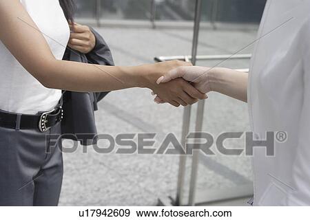 A midsection of two women seen shaking hands View Large Photo Image Stock Photo - A midsection of two women seen shaking hands. Fotosearch