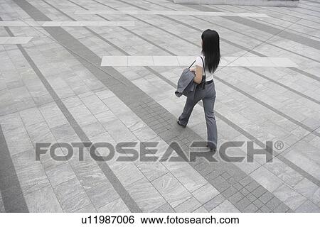 A rear view of a woman walking on a broad pathway View Large Photo Image Stock Photograph - A rear view of a woman walking on a broad pathway. Fotosearch