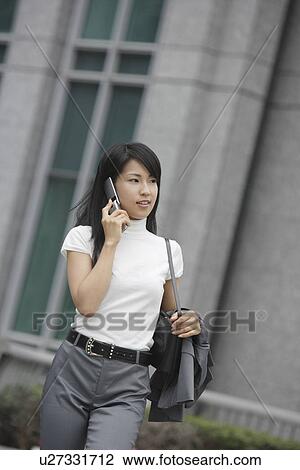 A woman moves on while conversing on the mobile phone View Large Photo Image Stock Image - A woman moves on while conversing on the mobile phone. Fotosearch