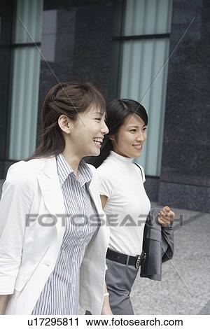 Two colleagues shares a joke as they are walking View Large Photo Image Stock Image - Two colleagues shares a joke as they are walking. Fotosearch