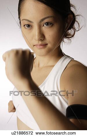 Stock Image - Close-up of a young woman exercising. Fotosearch