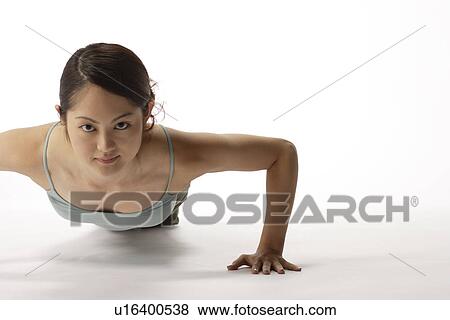 Stock Photo - Portrait of a young woman exercising pushup. Fotosearch