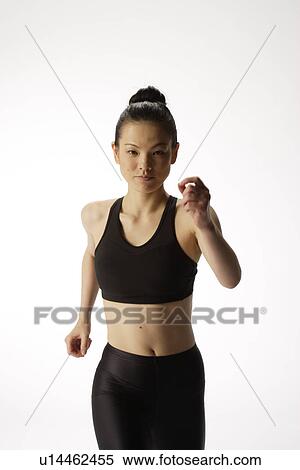 Stock Photography - Portrait of a young woman in a running position. Fotosearch