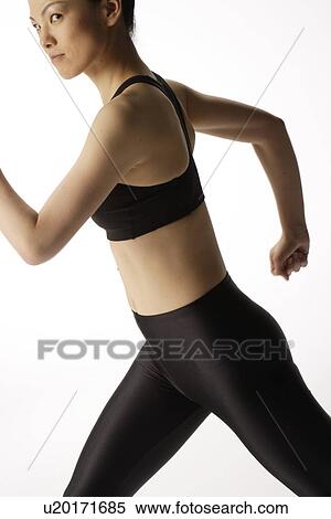 Stock Photography - Portrait of a young woman in a running position. Fotosearch