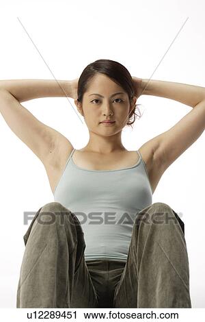 Stock Image - View of a young woman ding sit-up. Fotosearch