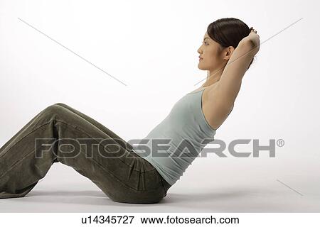 Stock Photo - View of a young woman doing sit-up. Fotosearch