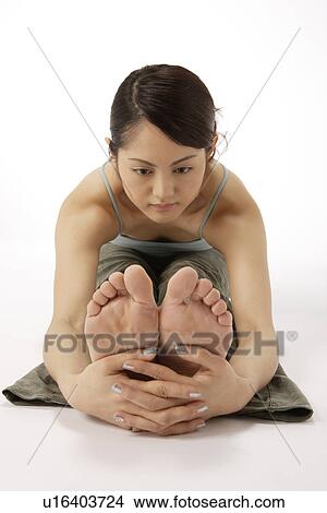 Picture - View of a young woman exercising on the floor. Fotosearch
