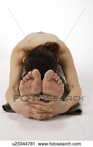 Stock Image - View of a young woman exercising on the floor. Fotosearch