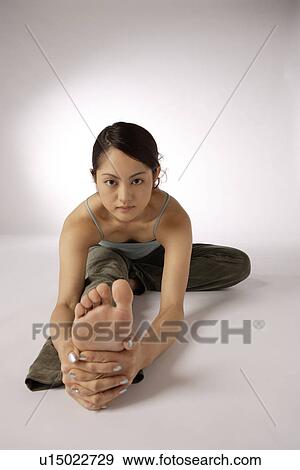 Stock Photo - View of a young woman exercising on the floor. Fotosearch