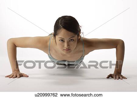 View of a young woman exercising pushup View Large Photo Image Stock Image - View of a young woman exercising pushup. Fotosearch