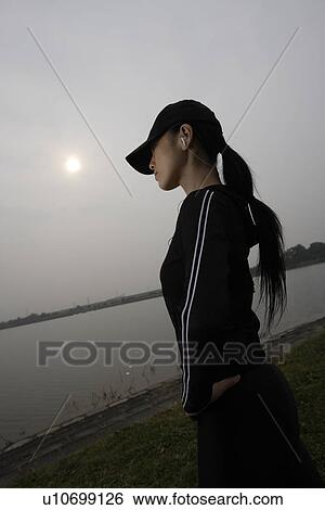 Stock Photograph - View of a young woman near a river. Fotosearch