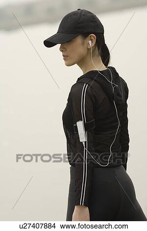 Picture - View of young woman carrying ipod on her arm. Fotosearch
