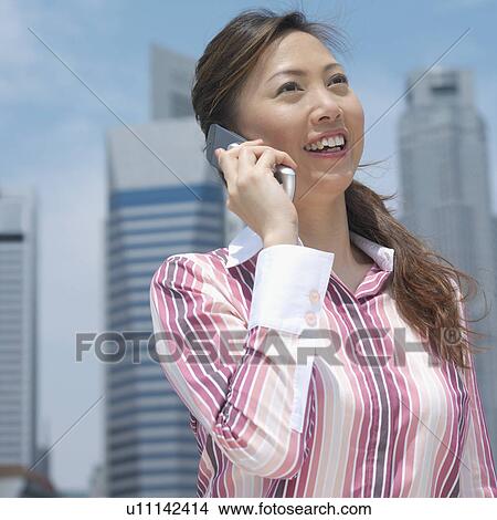 Close-up of a mid adult woman talking on a mobile phone View Large Photo Image Picture - Close-up of a mid adult woman talking on a mobile phone. Fotosearch