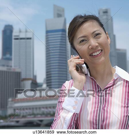 Close-up of a mid adult woman talking on a mobile phone View Large Photo Image Stock Photo - Close-up of a mid adult woman talking on a mobile phone. Fotosearch