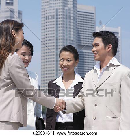 Low angle view of a businessman shaking hands with a businesswoman View Large Photo Image Stock Image - Low angle view of a businessman shaking hands with a businesswoman. Fotosearch