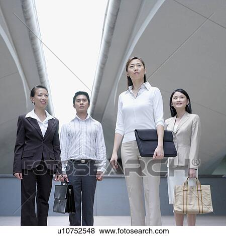 Low angle view of a businessman standing with three businesswomen View Large Photo Image Stock Photo - Low angle view of a businessman standing with three businesswomen. Fotosearch
