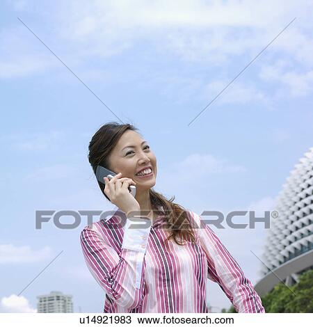 Low angle view of a mid adult woman talking on a mobile phone View Large Photo Image Stock Image - Low angle view of a mid adult woman talking on a mobile phone. Fotosearch
