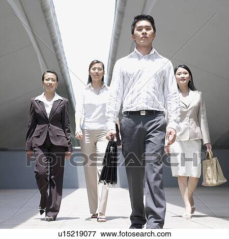 Portrait of a businessman walking with three businesswomen View Large Photo Image Stock Photo - Portrait of a businessman walking with three businesswomen. Fotosearch