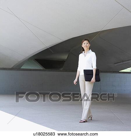 Stock Image - Portrait of a businesswoman holding a briefcase. Fotosearch