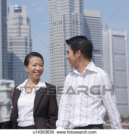 Stock Photography - Portrait of a businesswoman smiling with a businessman. Fotosearch