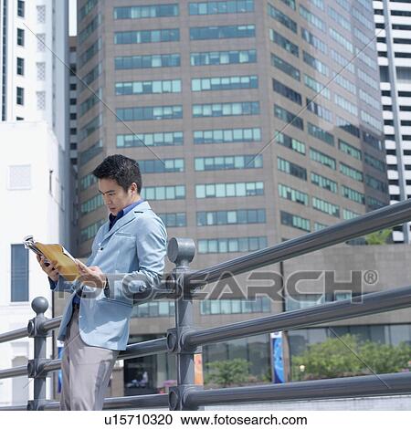 Side profile of a businessman reading a magazine View Large Photo Image Stock Image - Side profile of a businessman reading a magazine. Fotosearch
