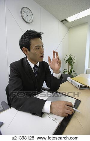Stock Photo - Businessman at his desk, portrait. Fotosearch
