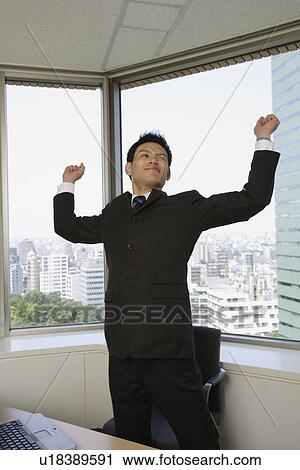 Stock Image - Businessman stretching his arms. Fotosearch