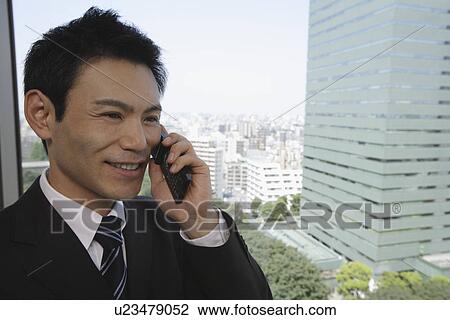 Stock Image - Businessman talking on his cellphone, portrait. Fotosearch