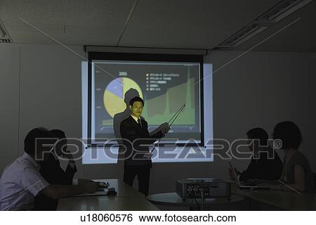 Stock Photograph - Businessman with a graphical representation at a conference. Fotosearch