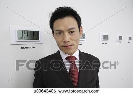 Stock Photography - Businessman with time zones, portrait. Fotosearch