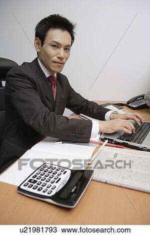 Businessman working on a laptop, portrait View Large Photo Image Stock Image - Businessman working on a laptop, portrait. Fotosearch